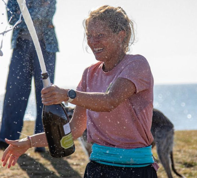 Megan Boxhall opening a bottle of Champagne on Sizewell beach