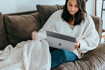 Woman lying on a sofa reading Only Good News Daily