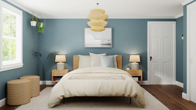 Bedroom painted in teal green, with dark wooden floorboards, and a white duvet.