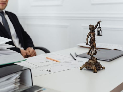 Lawyer with a small statue of the scales of justice on his desk