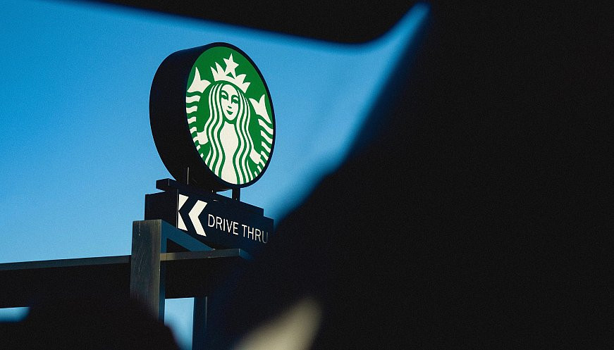 Illuminated Starbucks sign at a drive-thru