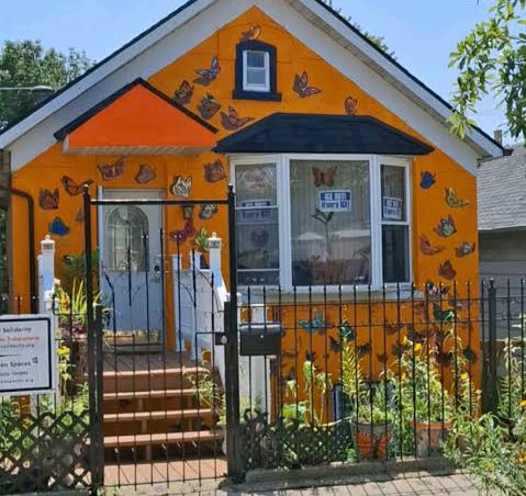 Small home painted orange with lots of butterflies painted on it