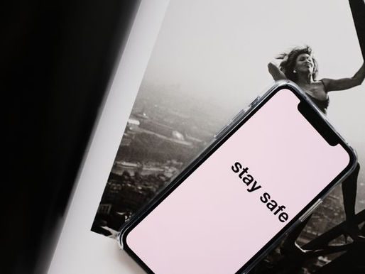 Woman holding a sign saying 'STAY SAFE'