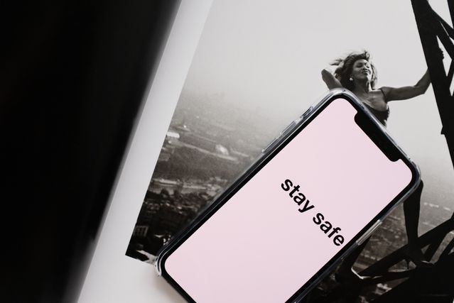 Woman holding a sign saying 'STAY SAFE'