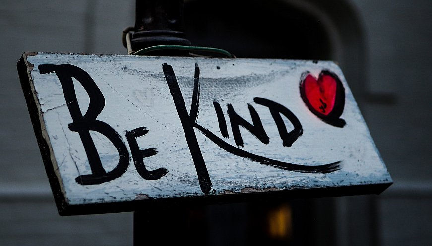 Little wooden sign with 'Be Kind' written on it