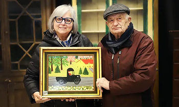 Irene and Tony Demas holding their Maud Lewis painting