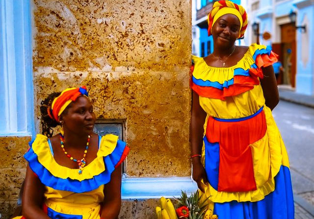 Two Caribbean women wearing traditional colourful clothing