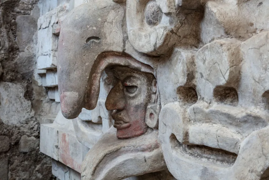 Sculpture of man's head inside an owls beak