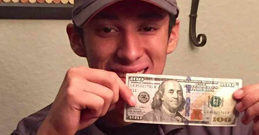 Smiling waiter holding his $100 tip
