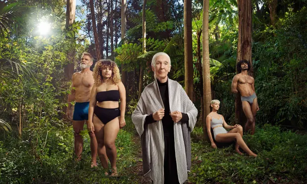 Jane Goodall standing in a lush jungle clearing flanked by models wearing bamboo underwear