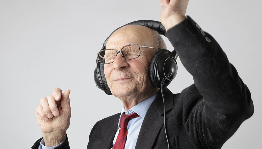 Old man listening to music on his headphones