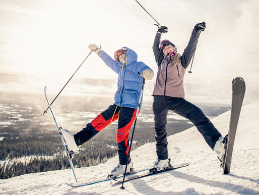 Two skiers traversing a mountain piste