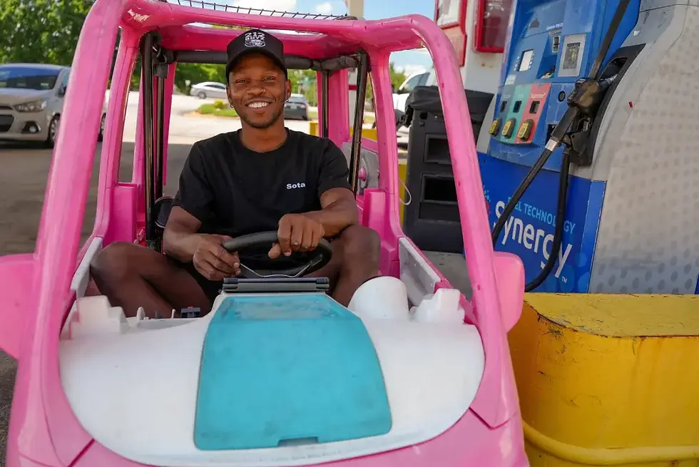 Man driving a Power Wheels Barbie Dream Camper