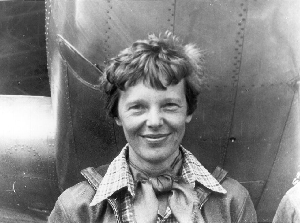 Amelia Earhart standing beside her Lockheed Electra 10-E