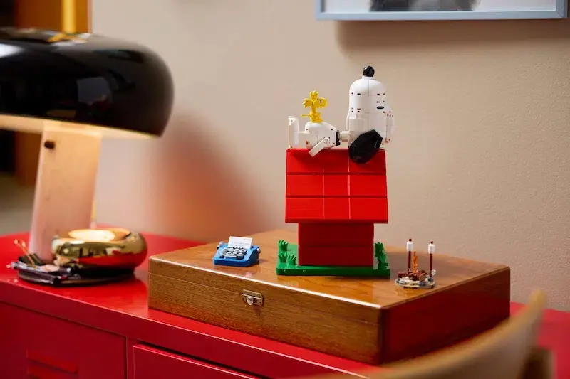A LEGO Snoopy stretched out on his rooftop