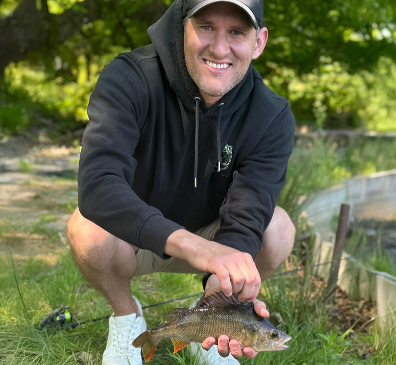 Dave Lyons, the founder of Tackling Minds, holding a just caught fish