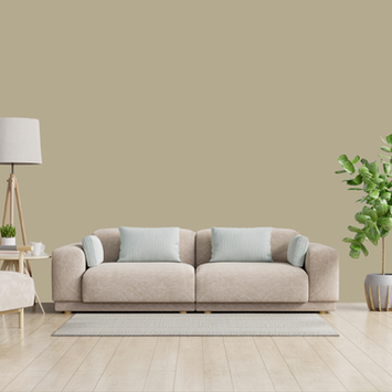 Modern living room with beige sofa, armchair, lamp, and green plants.