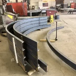 Large curved steel beams in a workshop, ready for assembly.