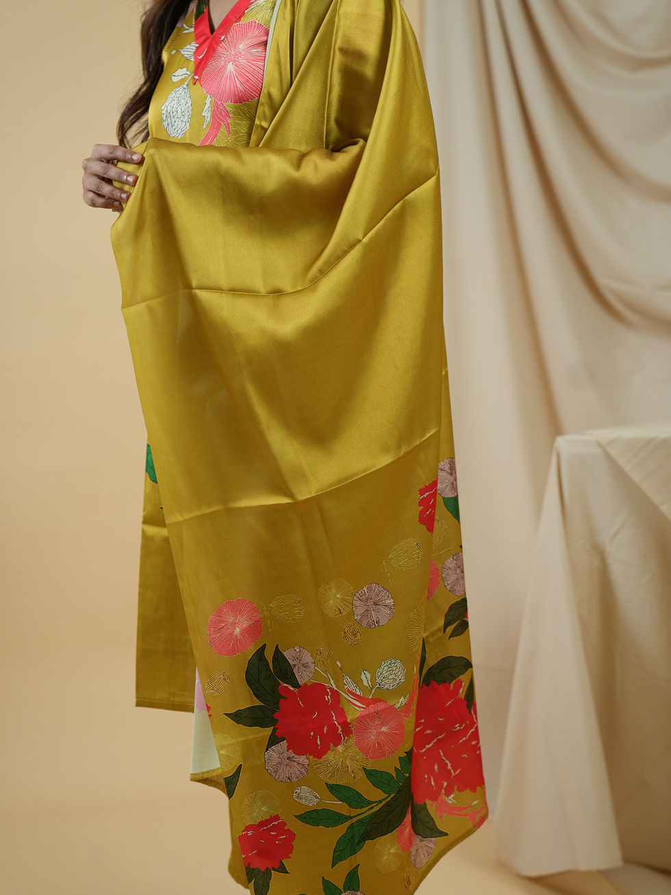 Woman wearing mustard kurta set with vibrant red floral prints.