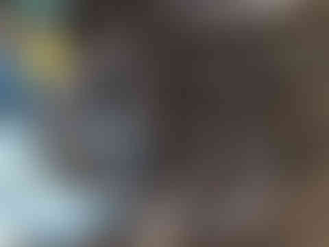 A stack of large circular rolled steel pipes in a metal workshop.