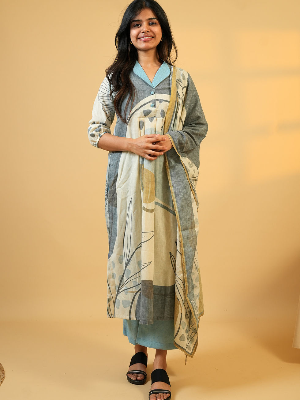 Woman standing in a stylish printed blue and grey kurta set.