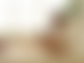 Mor holder sit barn tæt ind til sig i en kærlig omfavnelse. Barnet er iført en ble, og de deler et intimt øjeblik sammen.