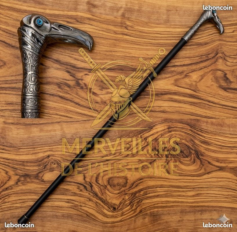 Réplique canne de marche Assassin's Creed 93cm, manche en tête d'oiseau sculptée et pommeau argenté sur fond bois.