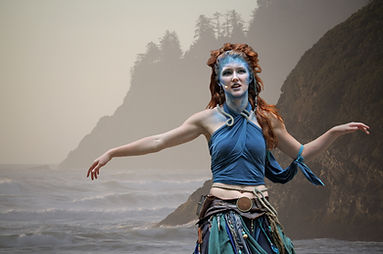 A blue-faced, red-haired, rag-drapped Siren emerges from the sea. I missed the top of her finger, but you can't really tell.