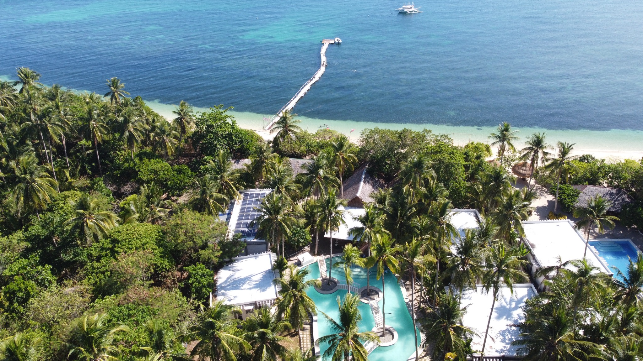 Aerial view of the resort, pool and beach at Pili Beach Resort