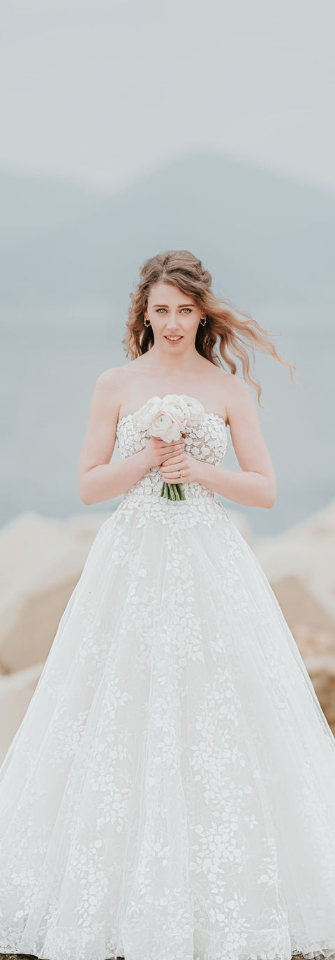 Portrait en pied de la mariée avec son bouquet, de face, devant la mer - photographe de mariage Grasse, Cannes, Nice
