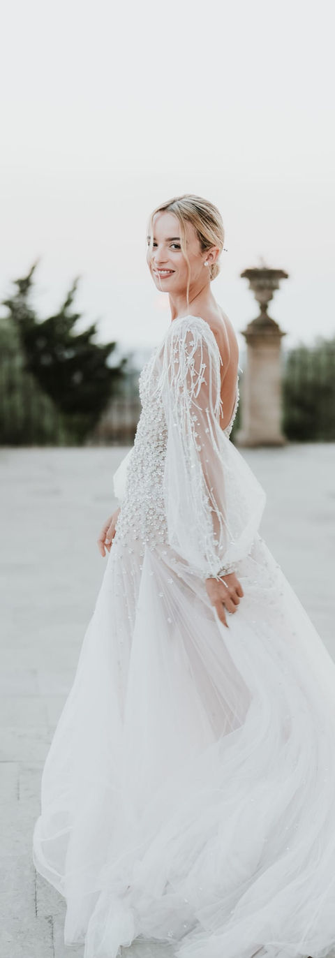 Sur la terrasse d'un palais sicilien, une jeune mariée se retourne en souriant et regarde l'objectif - robe de mariée - photographe de mariage Sicile, Italie, French Riviera