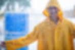 Smiling person in yellow raincoat during a Cape Town rainstorm