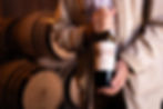 Man holding red wine bottle in a cellar, food photography cape town