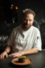 Chef posing for professional portrait photography with a plated dessert
