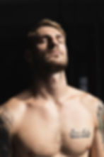 Professional portrait photography of a shirtless man with tattoos.