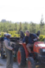 Professional portrait photography of farm workers by a tractor.