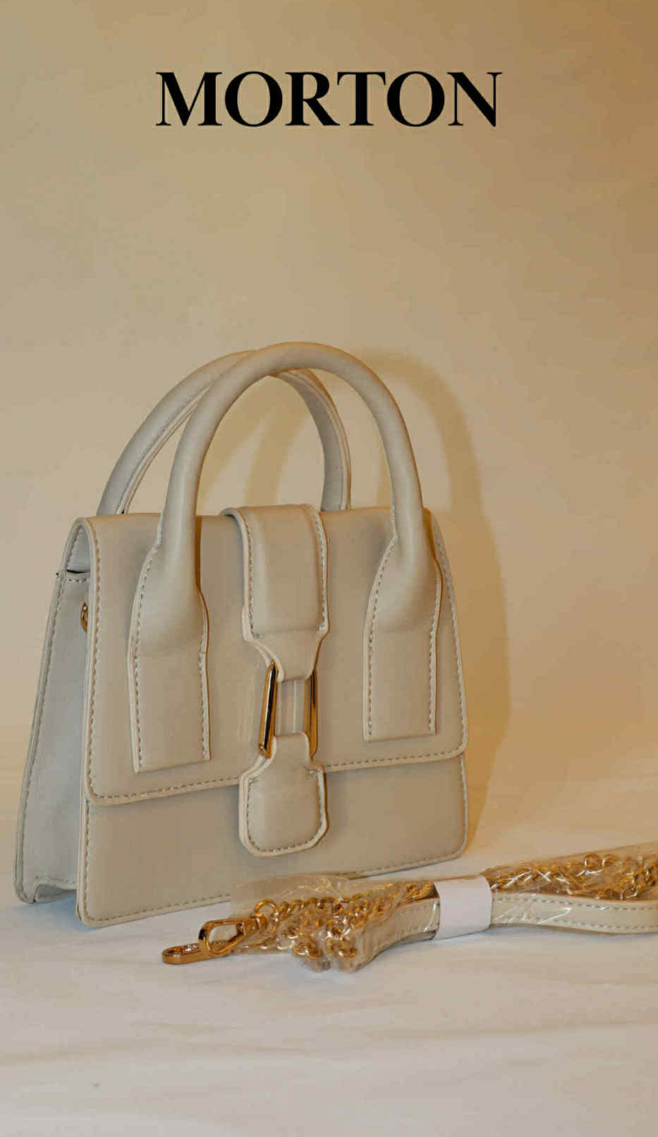 Morton taske med håndtag og spænde; elegant design på lys baggrund.