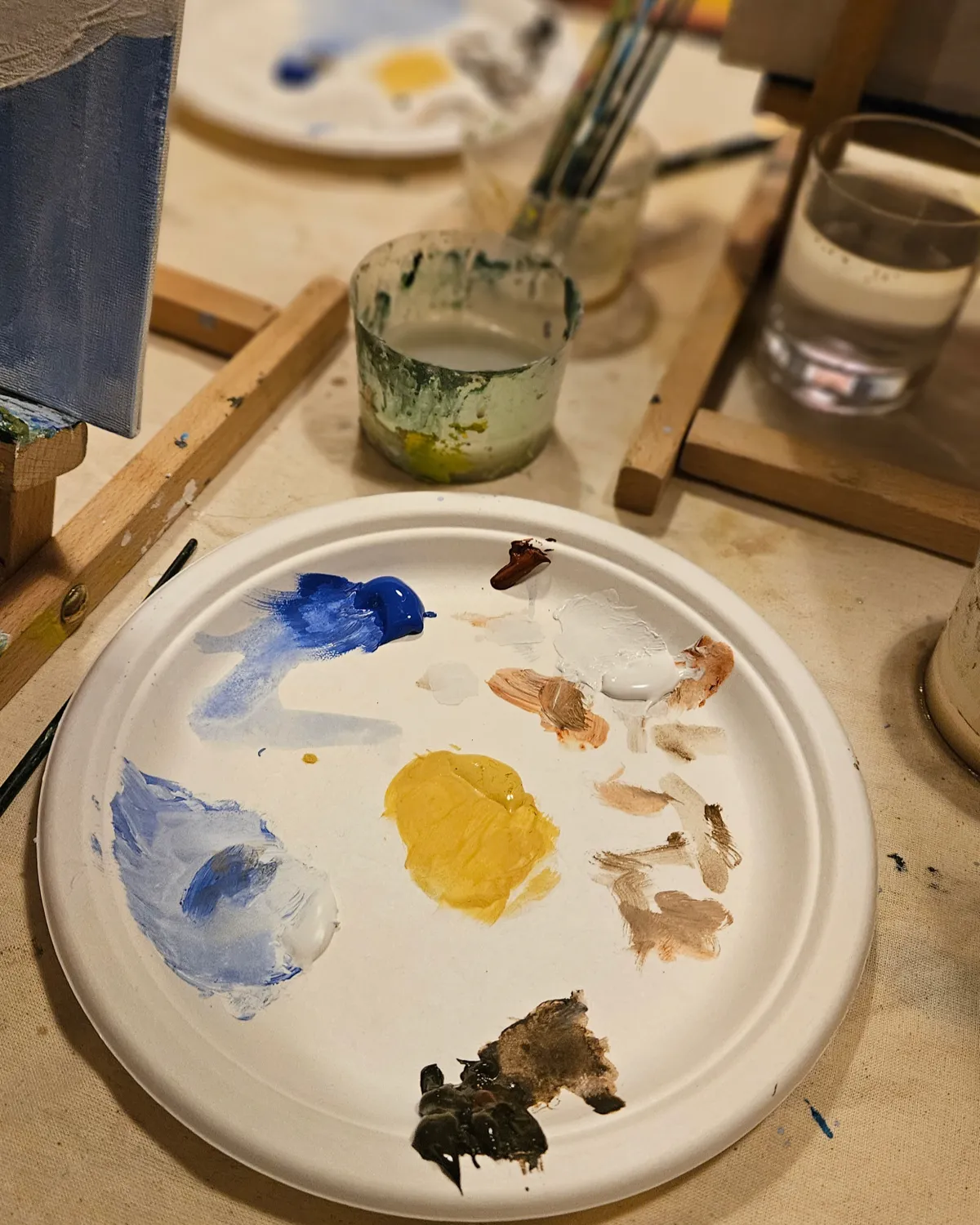 Paleta s bojama i kistovima tijekom kreativne Paint & Wine radionice na retreatu za mame.