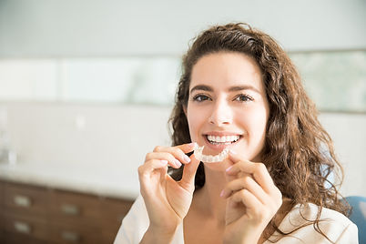 portrait-beautiful-patient-holding-orthodontic-retainers-dental-clinic.jpg