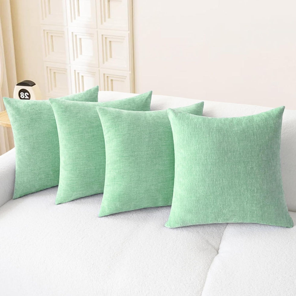 Four sage green chenille throw pillow covers on a white sofa
