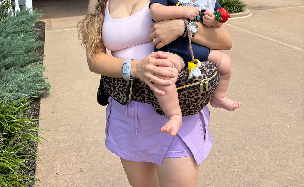 Tushbaby hip carrier review featuring the leopard-print carrier used for toddler carrying, Disney trips, errands, and everyday babywearing.