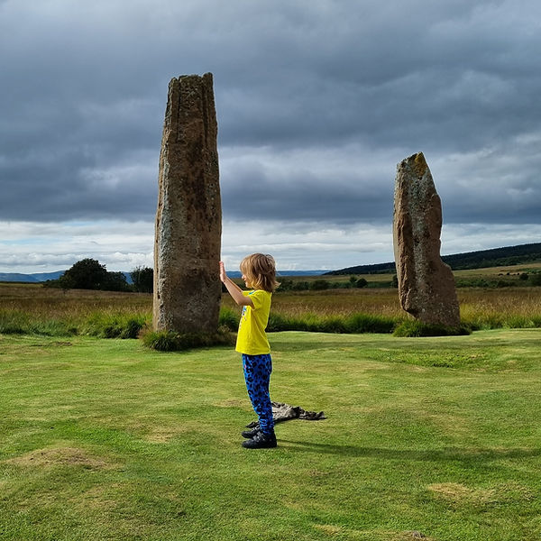 A child pushing against the standing stones on Machrie Moor