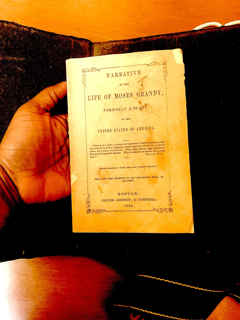 Holding the 1844 edition of Moses Grandy's narrative of enslavement. Albert and Shirley Small Special Collections, University of Virginia.