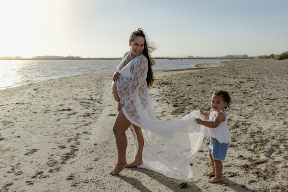 Pregnant woman in flowing dress on Werribee beach at sunset maternity session