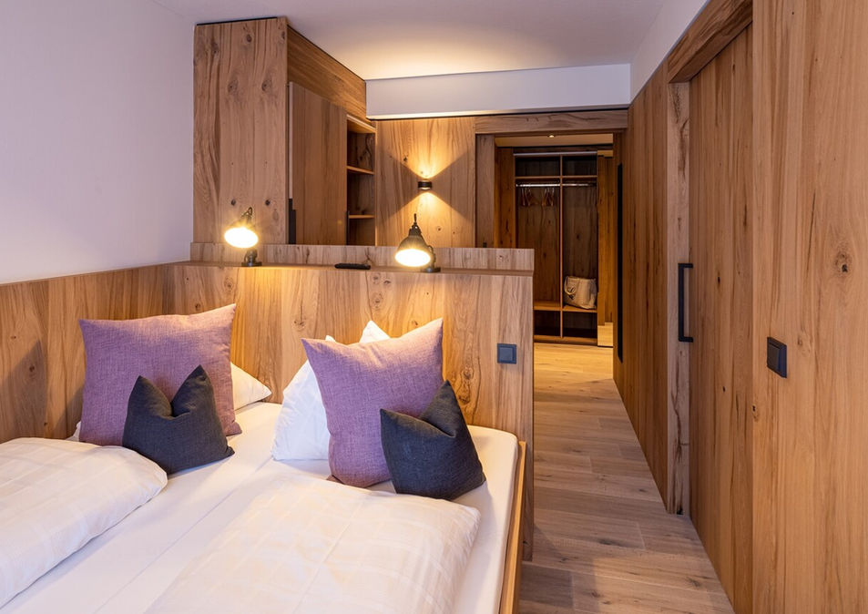 Gemütliches Hotelzimmer mit Doppelbett und Holzverkleidung