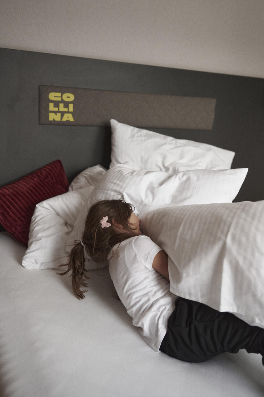 Kinder spielen im Bett im Hotel Garni Collina in Nauders