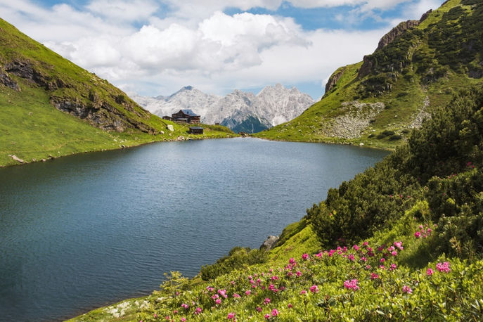 Bergsee mit Hütte und Alpenpanorama