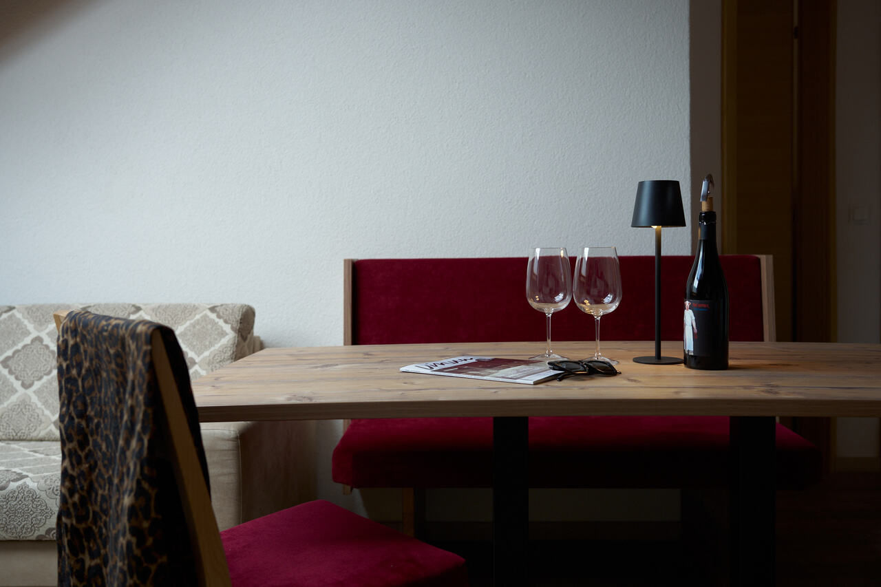 Esstisch mit Wein und Glaeser - Romantikurlaub im Hotel Garni Collina in Tirol
