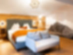 Modernes Schlafzimmer mit Holz, großem Bett und Bergbild