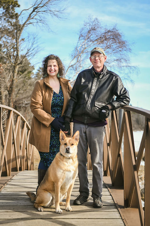 Emily stands with her husband and dog
